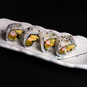 Tempting sushi rolls with avocado and crab sticks on a stylish ceramic plate.
