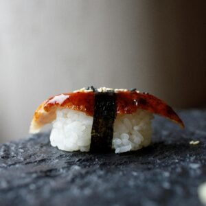 Gourmet Unagi Nigiri Sushi placed on a textured stone surface, showcasing traditional Japanese cuisine.
