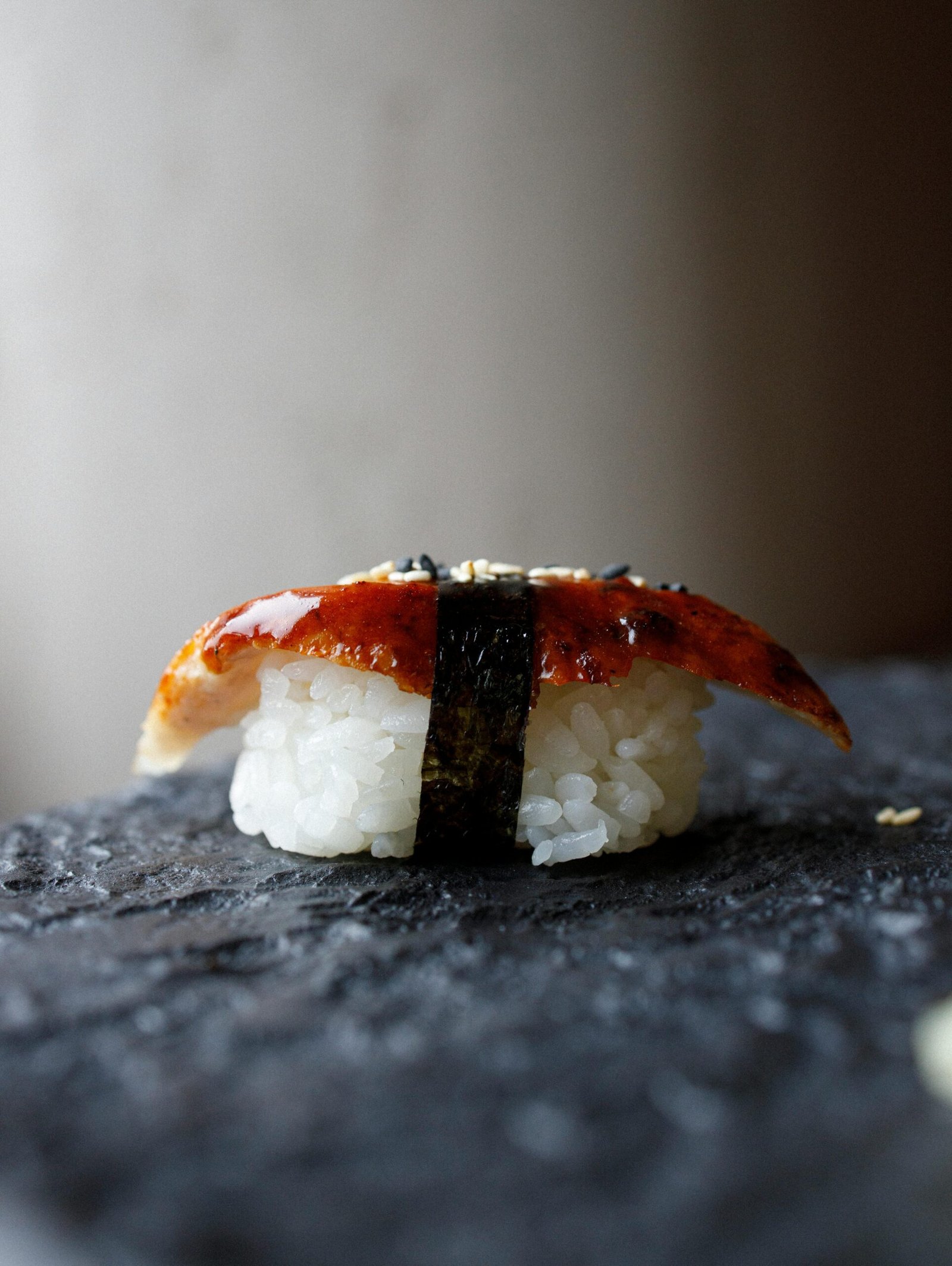 Gourmet Unagi Nigiri Sushi placed on a textured stone surface, showcasing traditional Japanese cuisine.