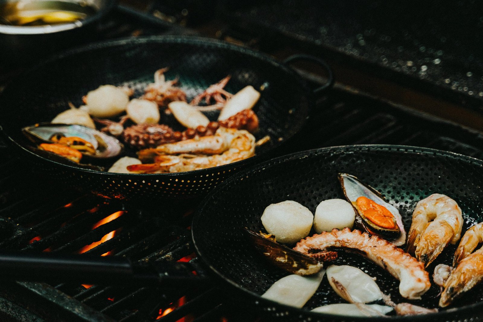 Close-up of a seafood medley grilling in a pan, featuring prawns, squid, and mussels. Perfect for cooking enthusiasts.