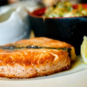 Delicious pan-seared salmon steak garnished with a lemon slice, showcasing a perfect dining experience.