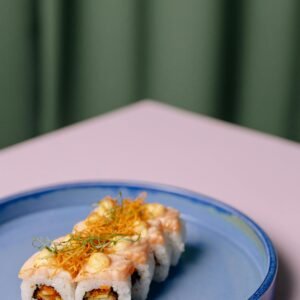 Close-up of a delicious sushi roll on a blue plate, showcasing culinary art.