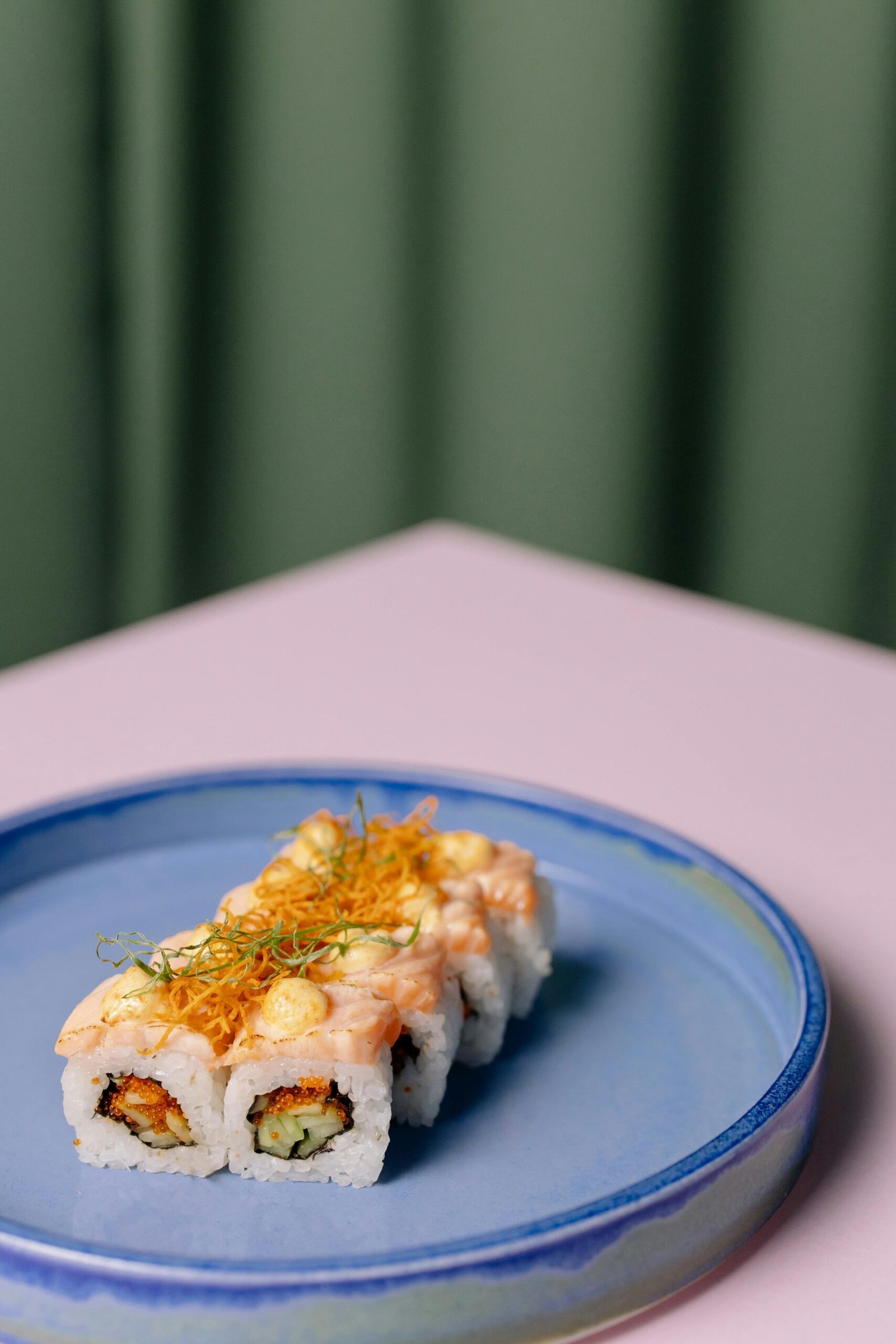 Close-up of a delicious sushi roll on a blue plate, showcasing culinary art.