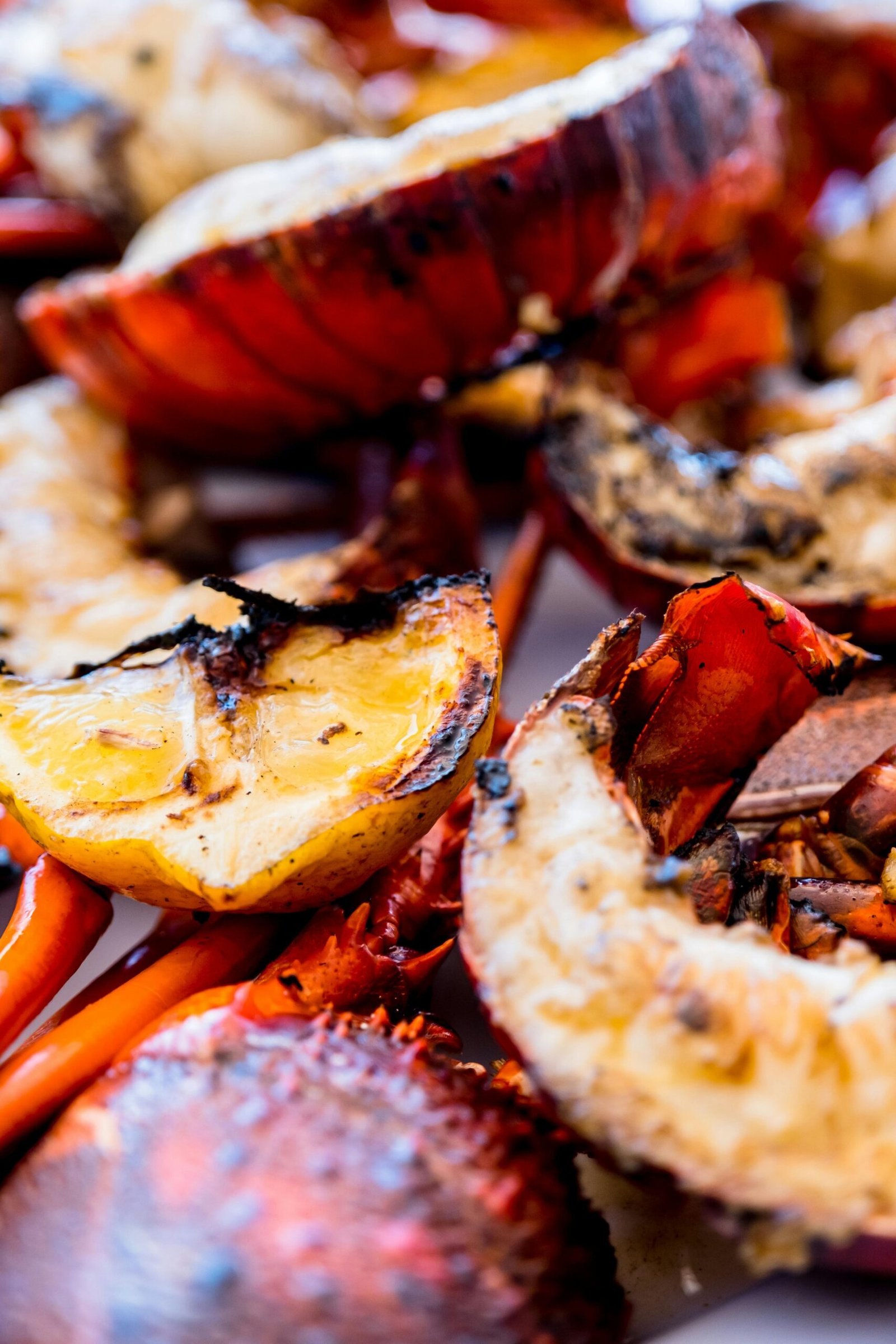Delicious grilled lobster tails with lemon slices, perfect for seafood lovers.